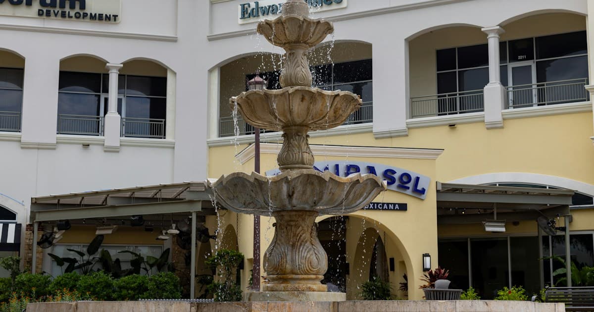 A fountain in front of restaurant and commercial storefronts in San Antonio, shown as illustrative retail stock.